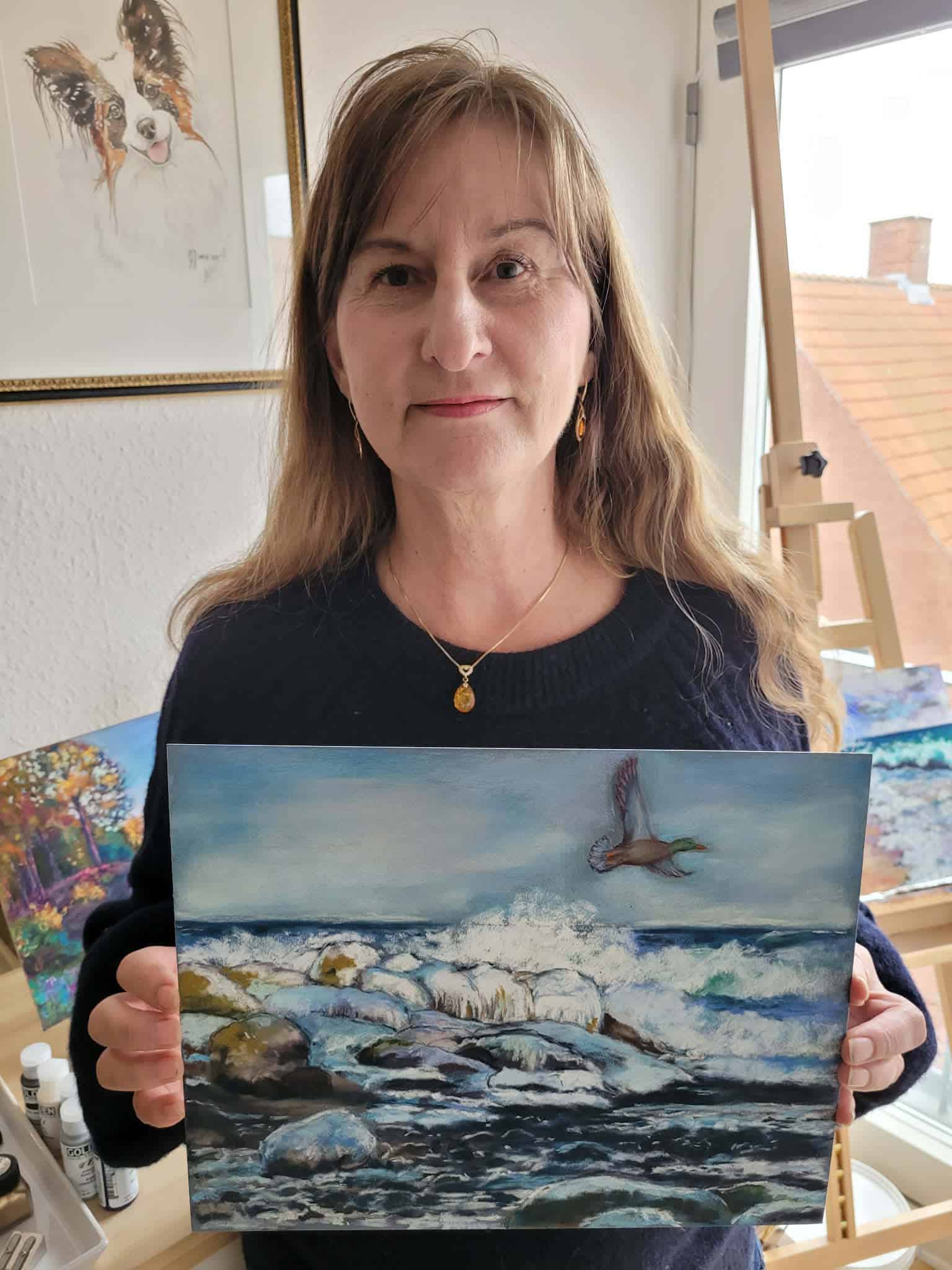 Aleah holding her soft pastel ocean landscape